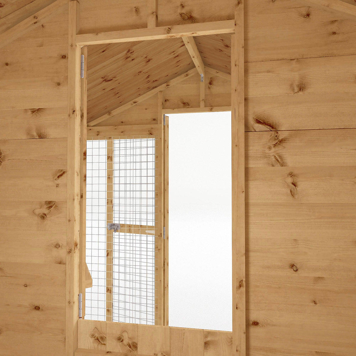 Interior view of wooden dog kennel leading to secure mesh run
